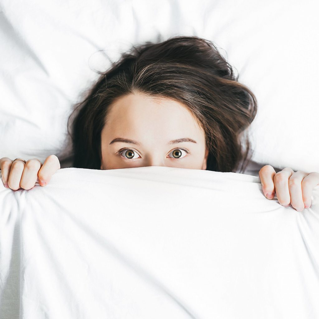 Woman hiding under covers